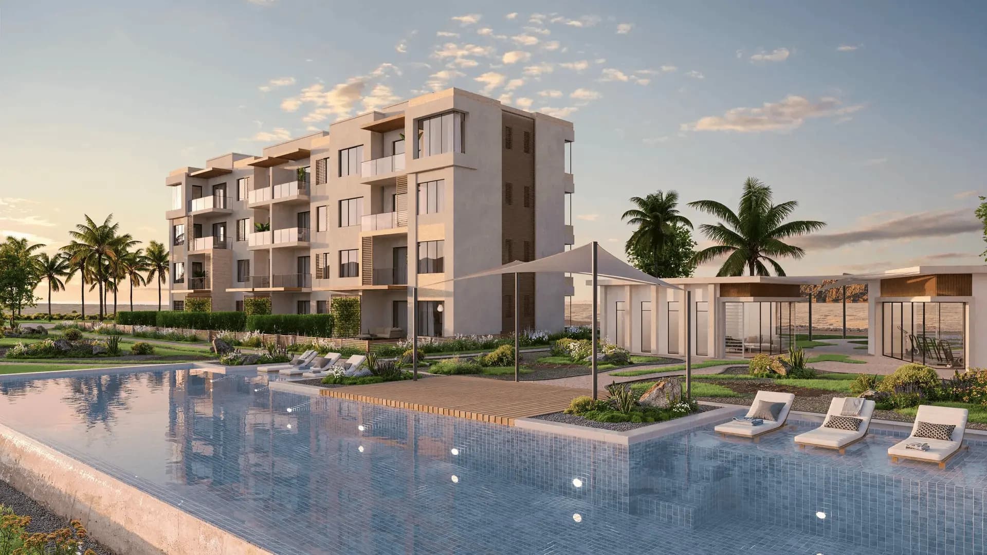 White apartment buildings arranged around a pool and palms